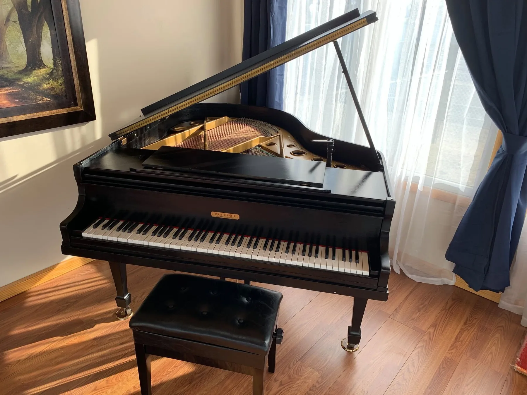The restored black grand piano reassembled and polished
